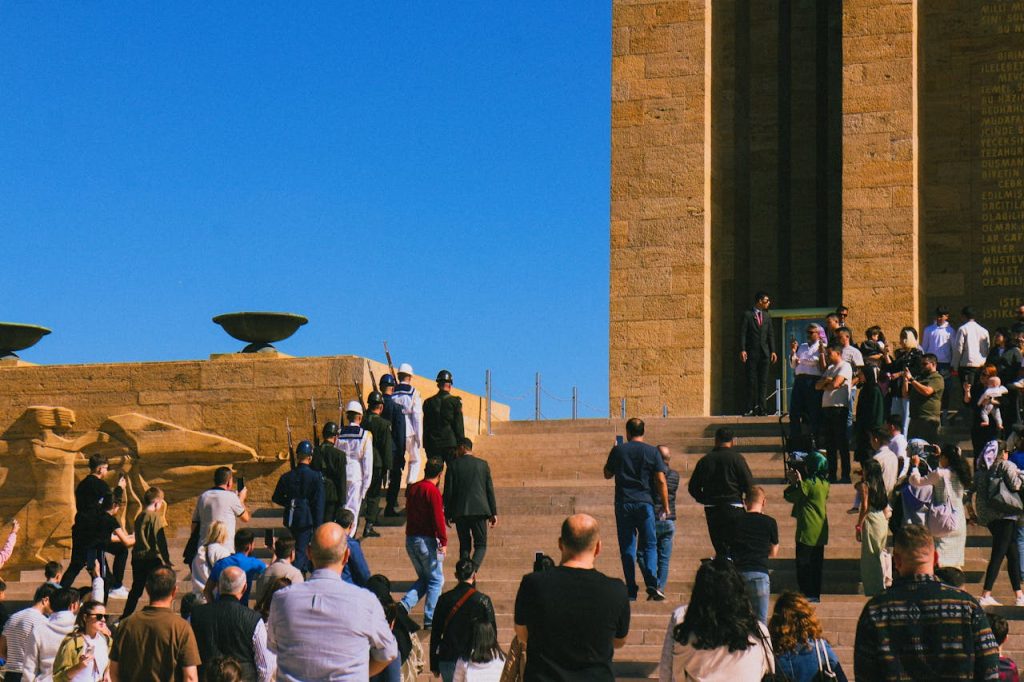 Crowd of tourists visiting a historic monument under a clear blue sky during the day.